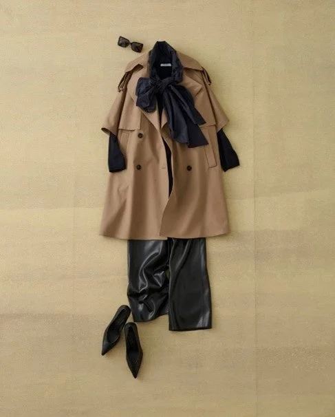 ベージュのトレンチコート、黒のワイドパンツ、黒のトップスのコーディネート