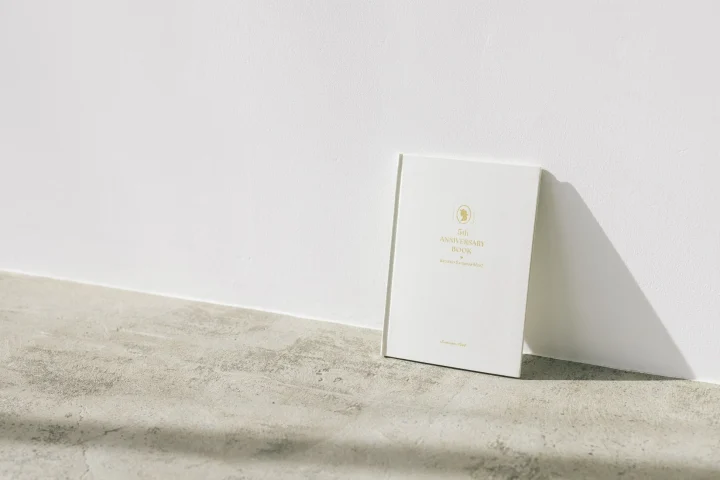 金色の文字がデザインされた白いアニバーサリーブック