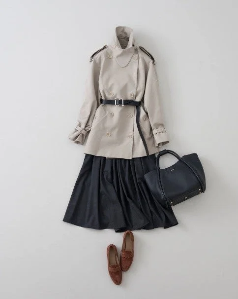 ベージュのトレンチコートと黒のプリーツスカートのコーディネート