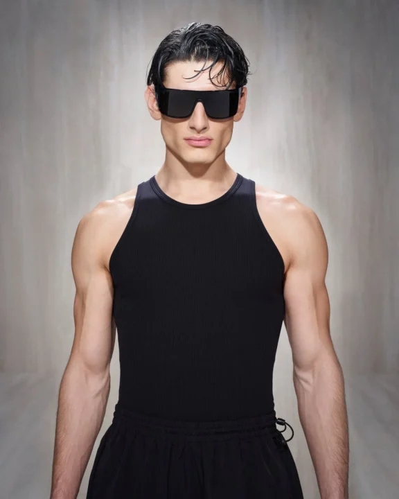黒いサングラスとリブ編みのタンクトップを着用した筋肉質な男性ポートレート