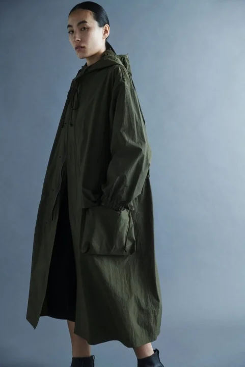 カーキ色のフード付きロングコートを着た女性モデル