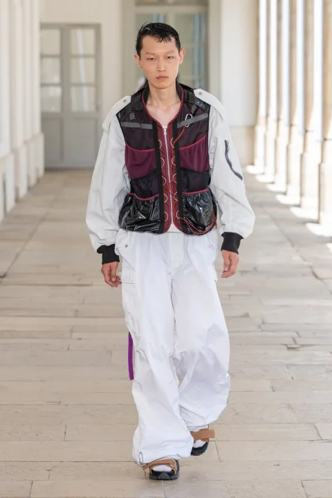 多機能ベストと白いカーゴパンツを合わせた男性モデル