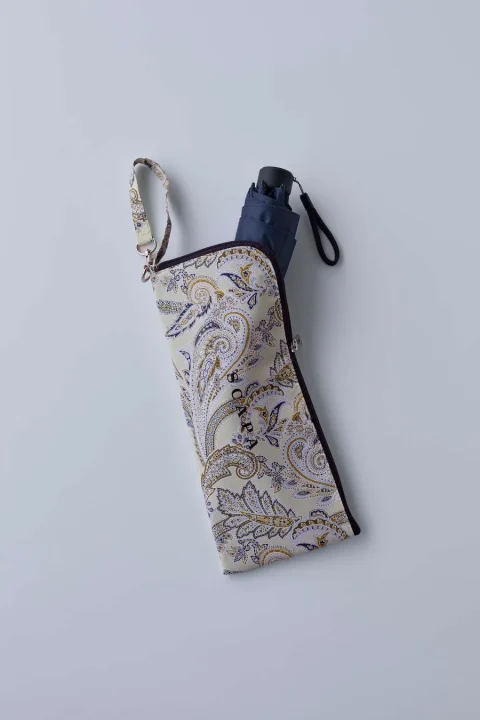 ペイズリー柄のケースに収納されたネイビーの折りたたみ傘