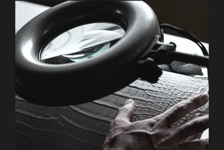 拡大鏡で革を検査する手