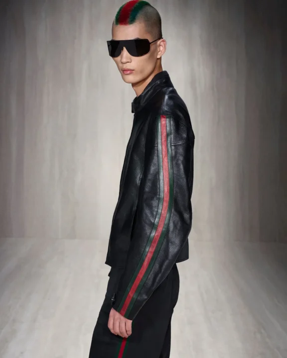 赤と緑のストライプが入った黒いレザージャケットを着た男性モデル