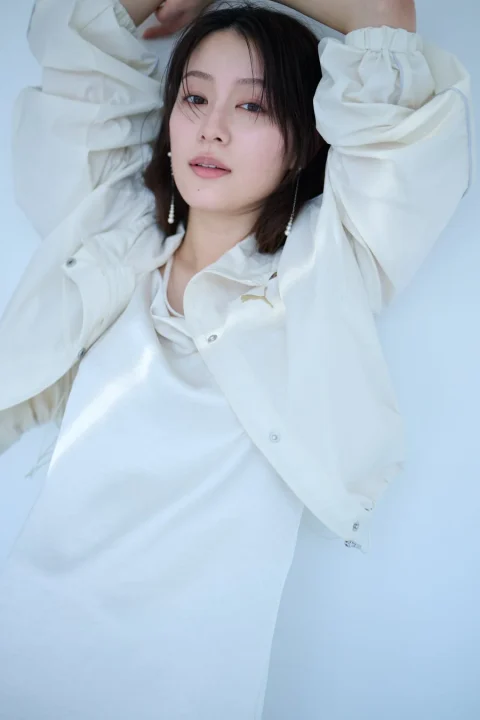 明るい背景の前でポーズをとる若い女性