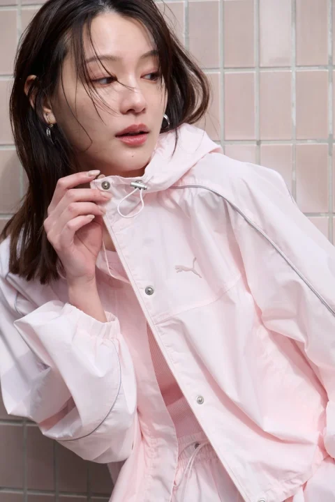 ピンクのプーマ製ウィンドブレーカーを着用した女性