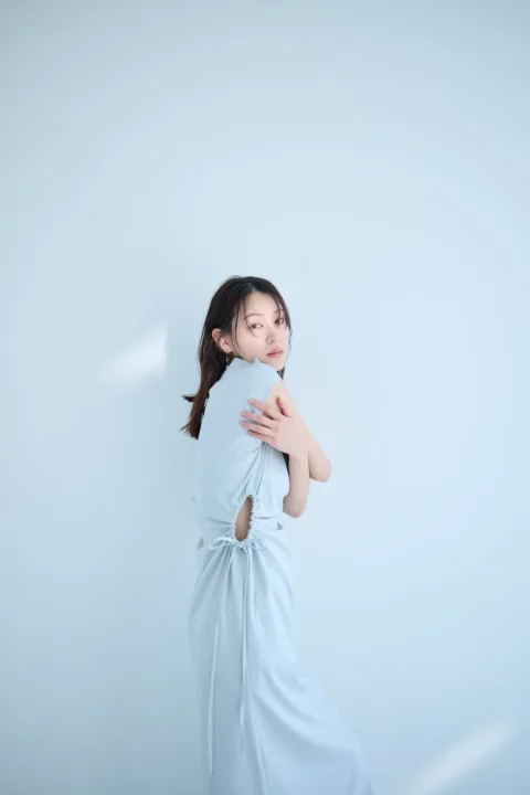 淡いブルーのノースリーブワンピースを着用した女性