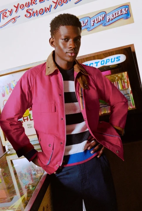 レトロなアーケードゲームの前でポーズをとる男性モデル