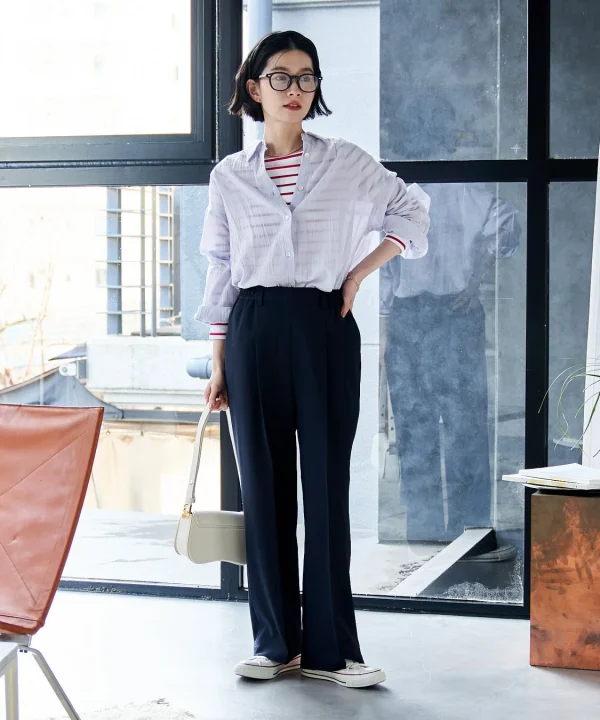 シアーシャツとボーダーT、ネイビーのワイドパンツを合わせた女性