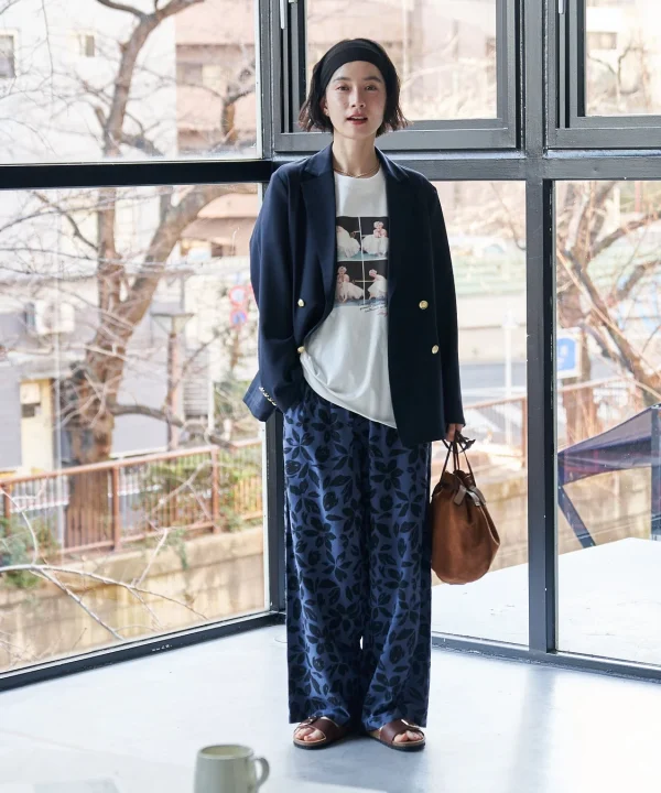ネイビーのブレザーと花柄のワイドパンツを着用した女性