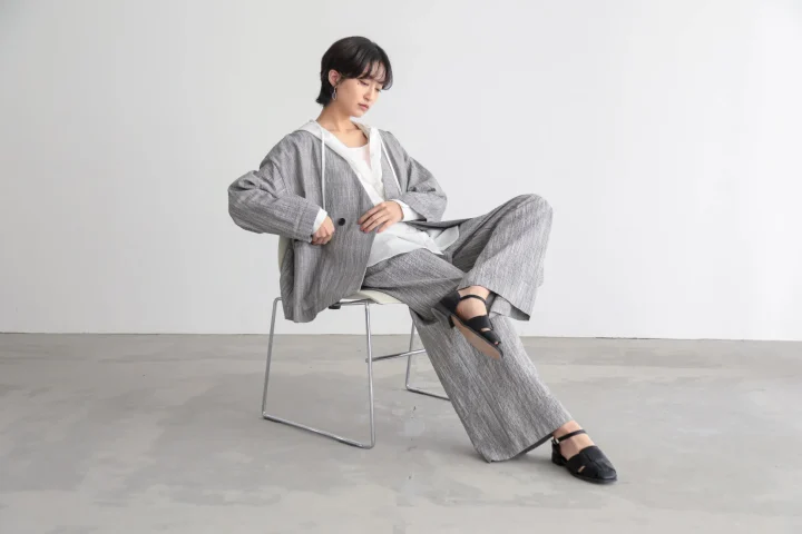 グレーのチェック柄セットアップを着用したショートヘアの女性