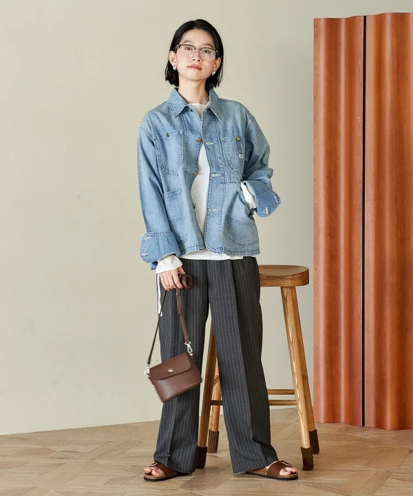 デニムジャケットとストライプのワイドパンツを合わせた女性