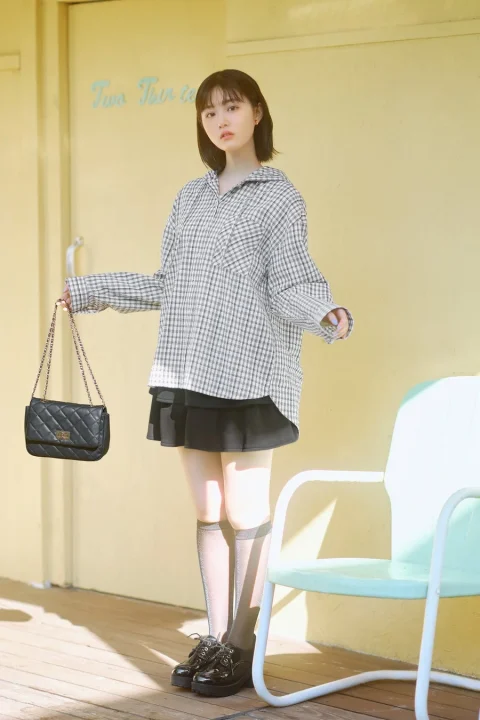 チェックシャツとミニスカートを着用しバッグを持つ原菜乃華さん