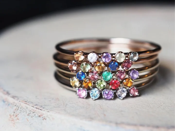 複数の細いリングに、様々な色の小粒な宝石が散りばめられた華やかなジュエリーのクローズアップ画像です。