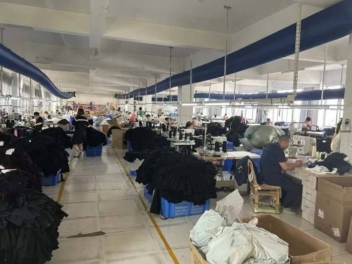 多くの従業員がミシンを使って作業している縫製工場の様子です