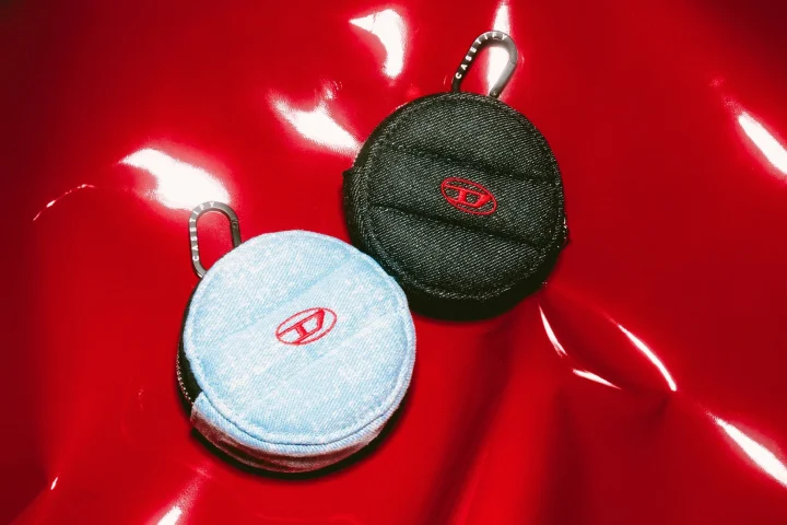 DIESELロゴ入りデニム素材の丸いポーチ2点。カラビナ付き。赤背景。