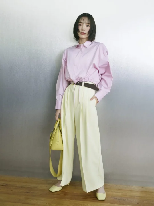 ピンクのストライプシャツと淡いイエローのワイドパンツ