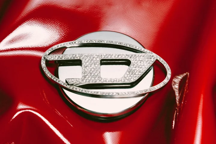 ダイヤモンドがちりばめられたディーゼルの「D」ロゴ。赤背景。