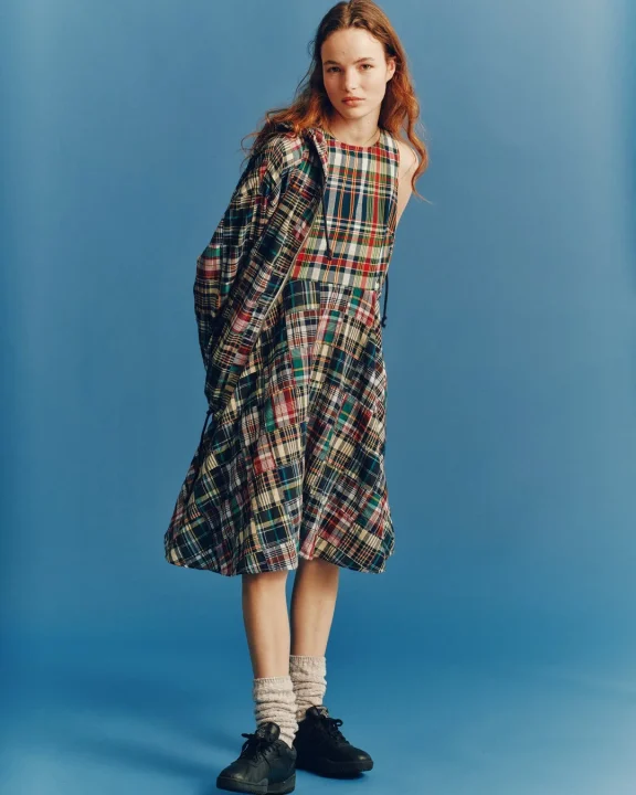 チェック柄ワンピースとジャケットを着用した女性