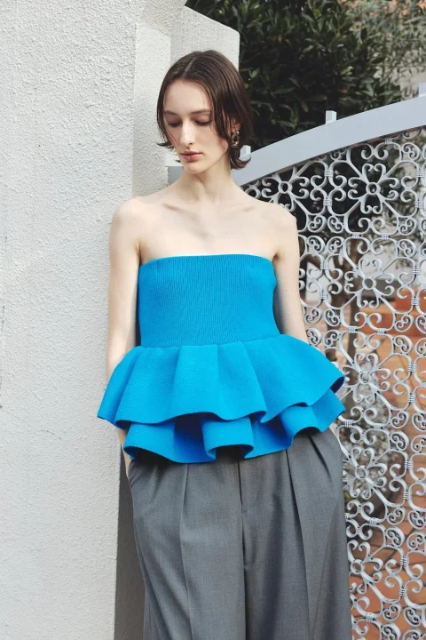 青いチューブトップとグレーのワイドパンツ