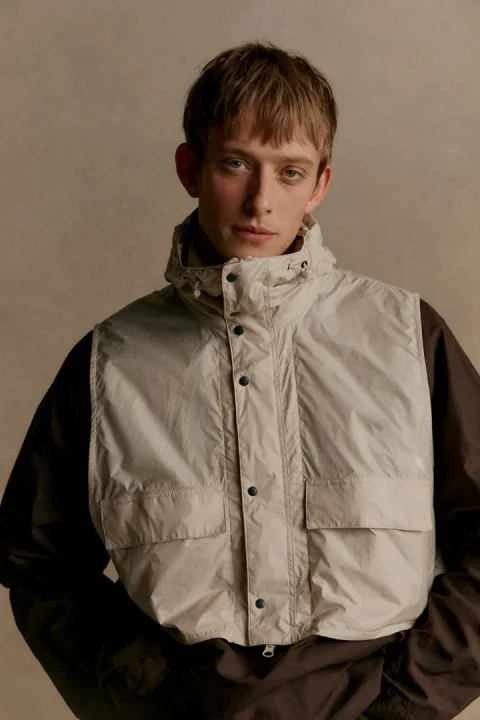フード付きベストを着用した男性モデル