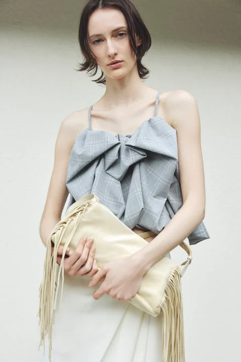 グレーのチェック柄トップスと白いスカート