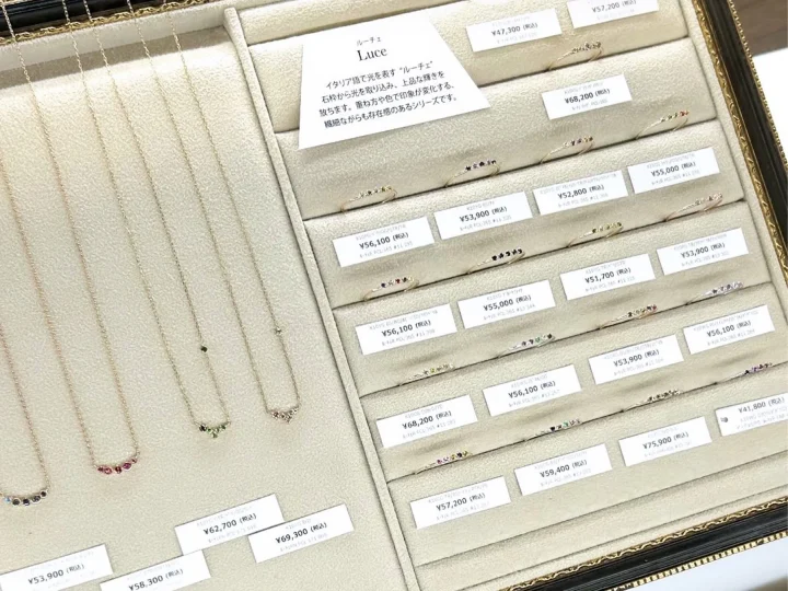 宝石があしらわれた繊細なリングとネックレスが並ぶジュエリーディスプレイ。