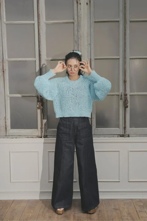 水色のニットとワイドデニム、メガネをかけた柴咲コウ