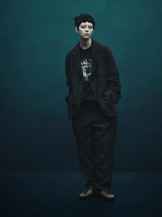 ショートヘアの人物が立つポートレート