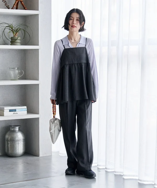 ピンストライプのキャミソールとパンツのセットアップを着た女性