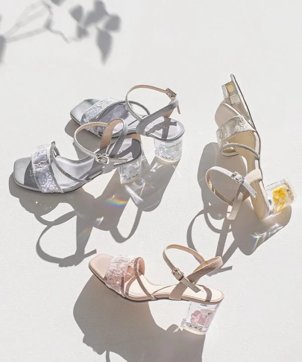 クリアヒールの中に花が閉じ込められたフェミニンなデザインのサンダル