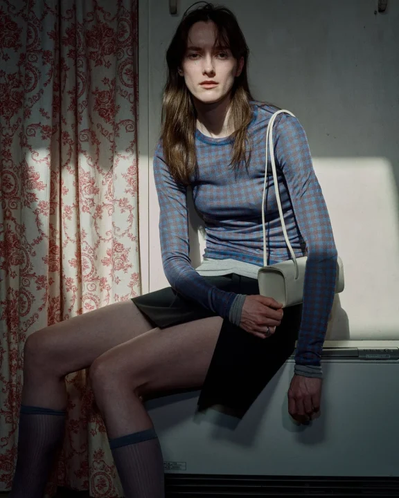 チェック柄の長袖トップスとミニスカートを着用した女性