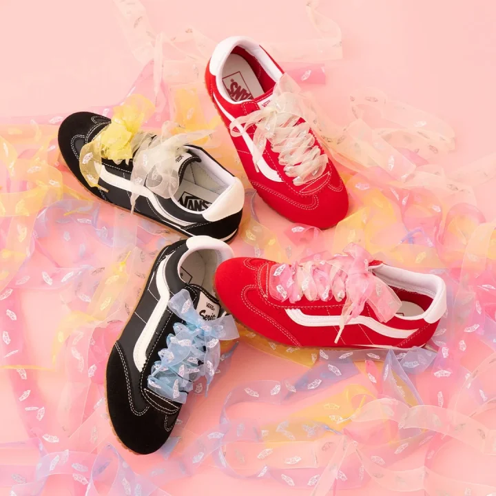 ピンクの背景に並べられたVansスニーカーとカラフルなリボン