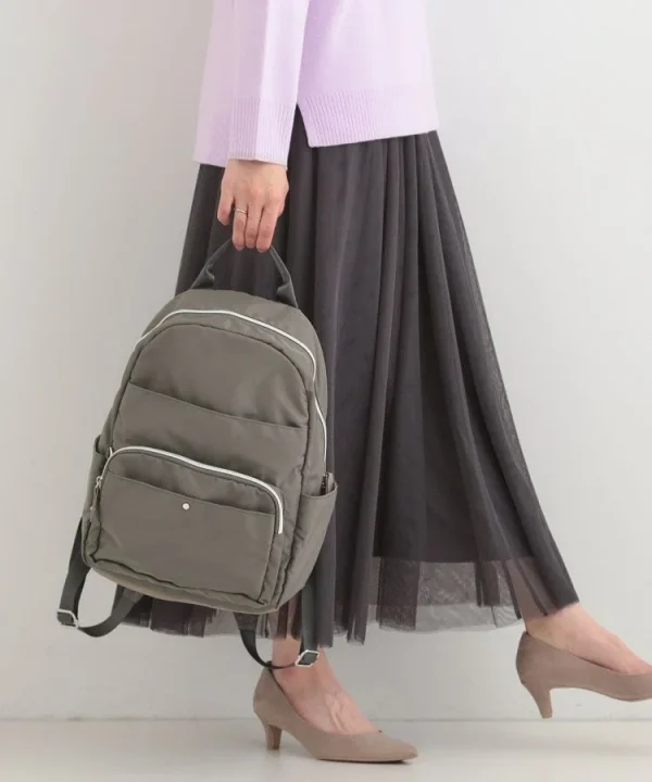 グレーのリュックを持つ女性