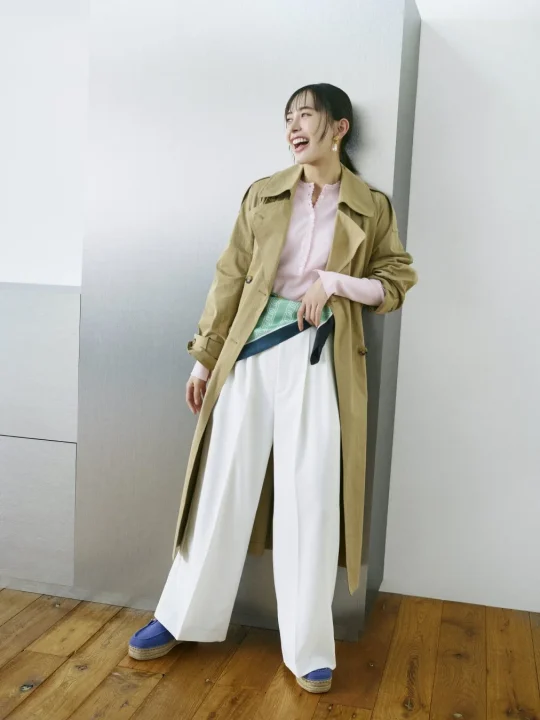 ベージュのトレンチコートと白のワイドパンツ