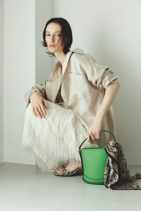 ベージュのシャツとフリンジスカート