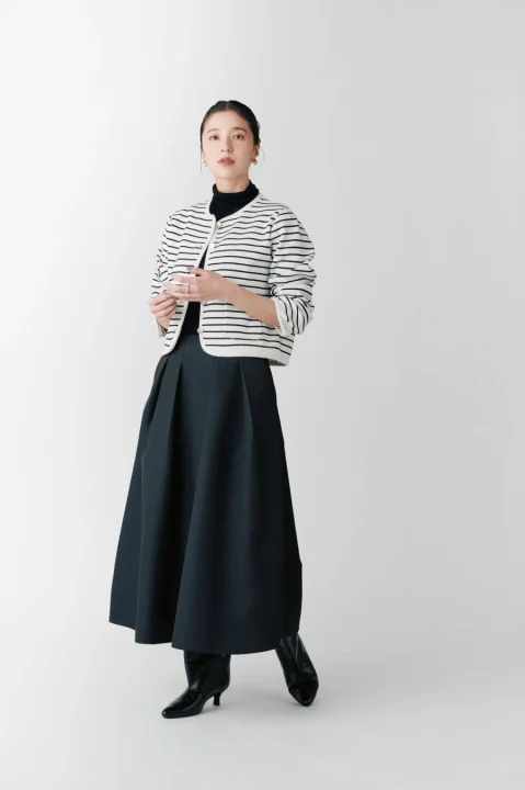 ゴールドボタンニットジャケットを着こなすモデル