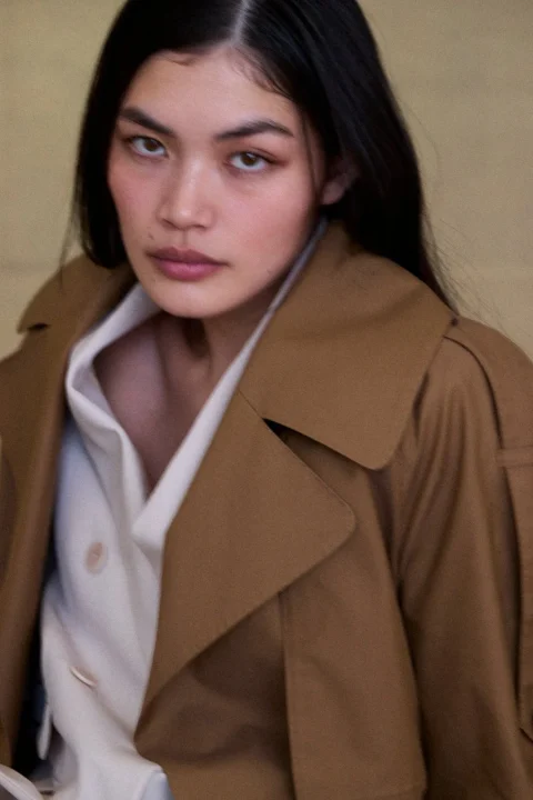 トレンチコートと白シャツを着た女性のクローズアップポートレート