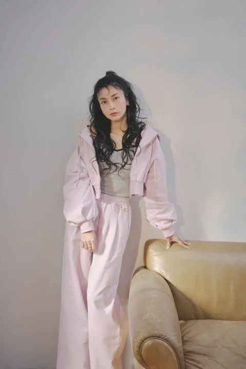 ピンクのクロップド丈パーカーとワイドパンツの全身像