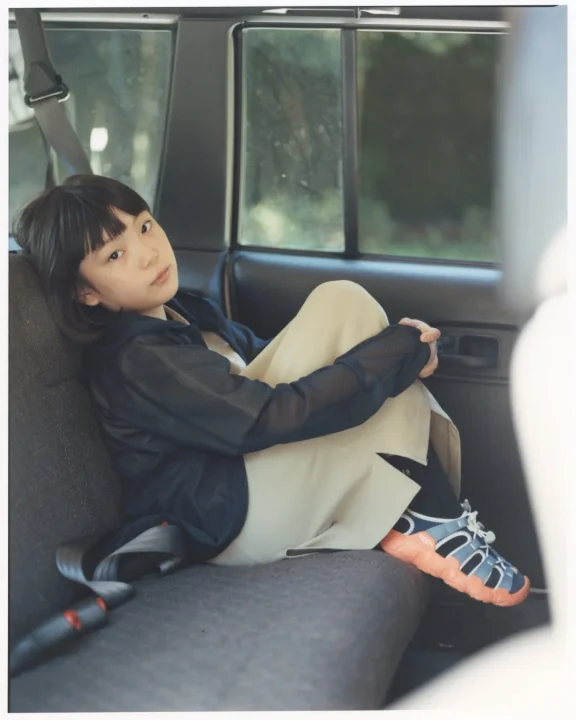 車内後部座席に座るショートヘアの女性