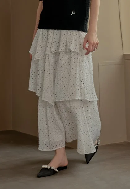 ドット柄ティアードスカートと黒トップス、パール飾りのミュール