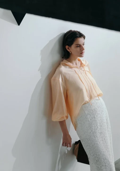 淡いピーチ色のブラウスと白いレースのスカート