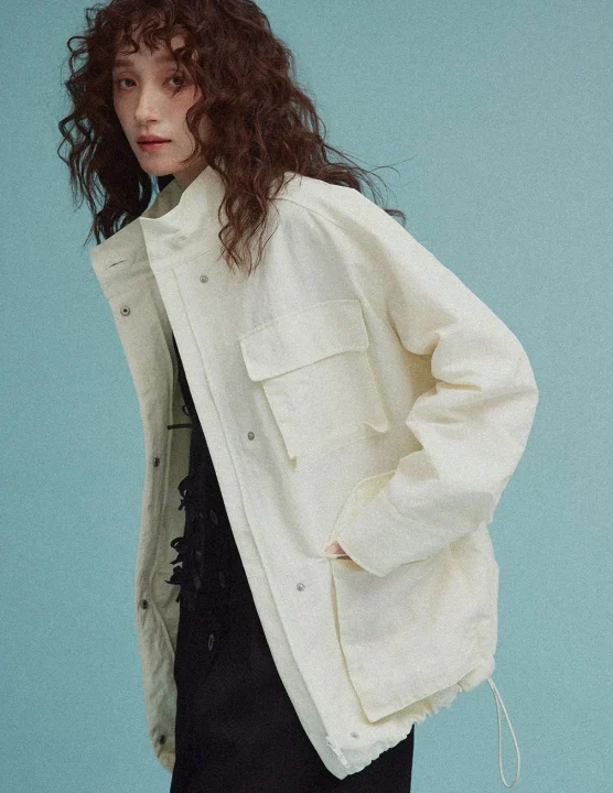 白いスタンドカラージャケットを着用した女性