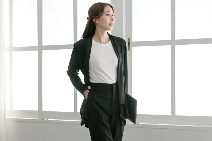 窓辺でノートパソコンを持つ女性