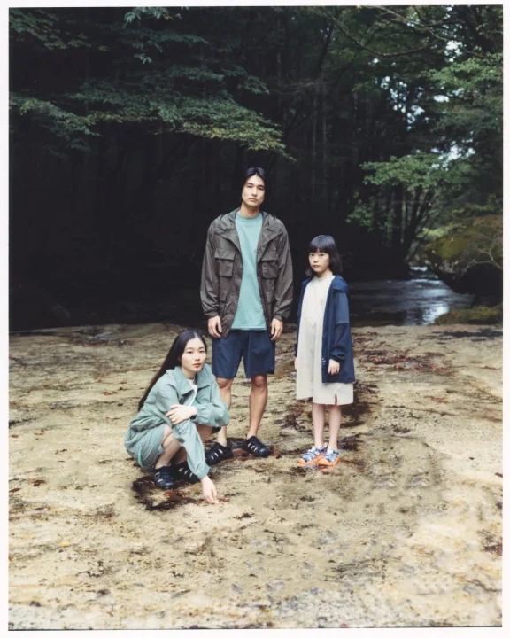 家族が森林の渓流沿いに並ぶ様子