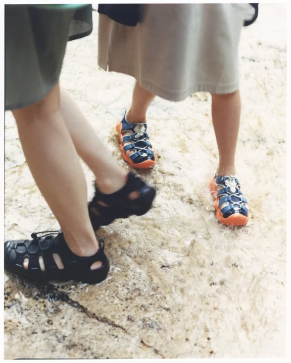 黒と青・オレンジのサンダルを履いた足元
