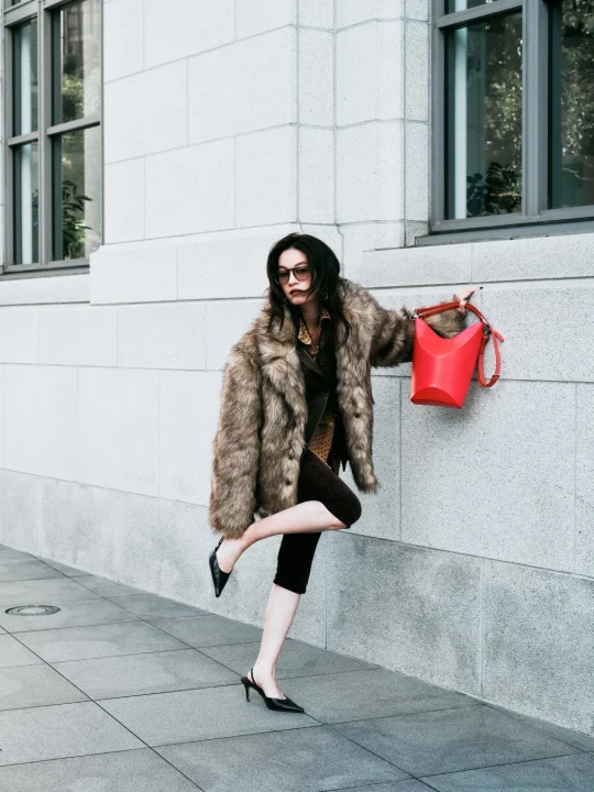 ファーコートと赤いバッグを身につけた女性