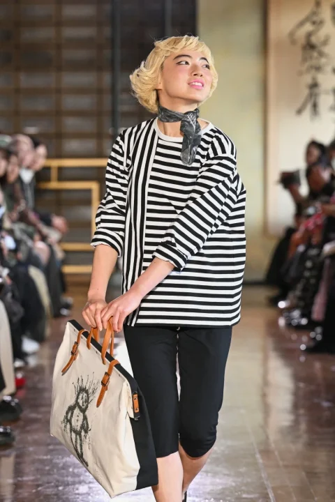 ボーダー柄トップスとトートバッグを持つ女性モデル
