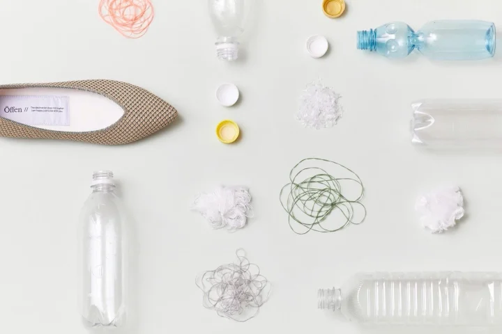 リサイクル素材から作られたとみられるフラットシューズと、その原材料となるペットボトルや再生プラスチック、繊維